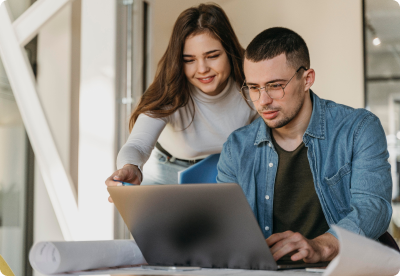 A man and a woman in front of a laptop