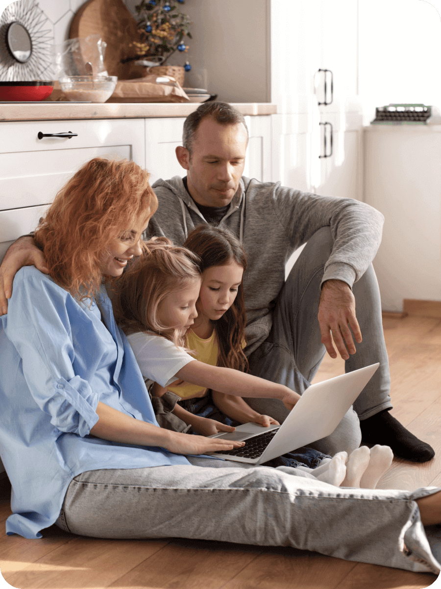 A family is lying on the floor reviewing their insurance benefits.